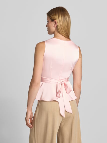 Frauenmodel trägt Blusentop in Wickel-Optik Modell 'Risetta' von Neo Noir in Rosa, Material-Mix mit Stretch, Ganzkörperansicht Rückansicht.