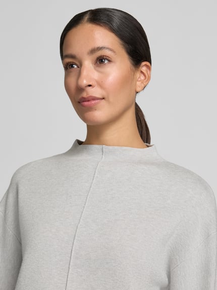 Frauenmodel trägt Strickpullunder Modell 'Punus' mit Mock Neck von OPUS in unifarbener Optik, hochgeschlossen, Nahaufnahme Oberkörper.