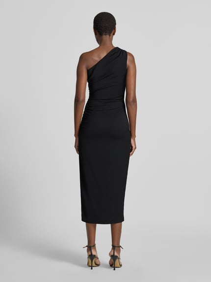 Frauenmodel trägt Eng anliegendes Cocktailkleid mit One-Shoulder von Jake*s Cocktail in Schwarz, glatte Textur, Ganzkörperansicht Rückansicht.