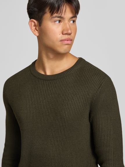 Männermodel trägt Strickpullover mit Rundhalsausschnitt Modell 'PANNEL' von JACK & JONES, Olivgrün, fein gerippte Struktur, Nahaufnahme Oberkörper, Material-Mix mit Baumwoll-Anteil, eng anliegender Schnitt.