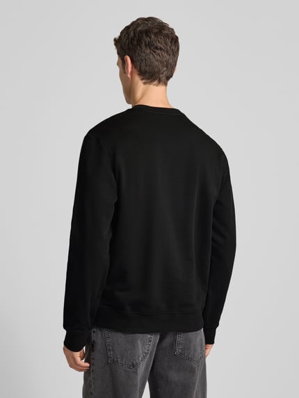 Männermodel trägt Sweatshirt mit Label-Detail Modell 'Dem' von HUGO in Schwarz, Reine Baumwolle, lockere Passform, gerippte Abschlüsse, Ganzkörperansicht Rückansicht.