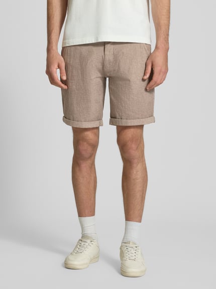 Männermodel trägt Bermudas mit Gürtel und Eingrifftaschen Modell 'NEBRASKA' von Redefined Rebel, Beige, Baumwoll-Mix mit Stretch-Anteil, Straight Fit, Ganzkörperansicht von vorne. Bundweite bei Größe L: 46 cm, Innenbeinlänge bei Größe L: 21 cm, Knopf- und Reißverschluss, französische Eingrifftaschen, Gesäßleistentaschen.