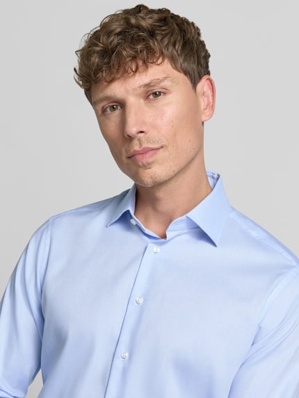 Männermodel trägt Regular Fit Business-Hemd mit Kentkragen von Christian Berg Men in Hellblau, reine Baumwolle, Nahaufnahme Oberkörper.
