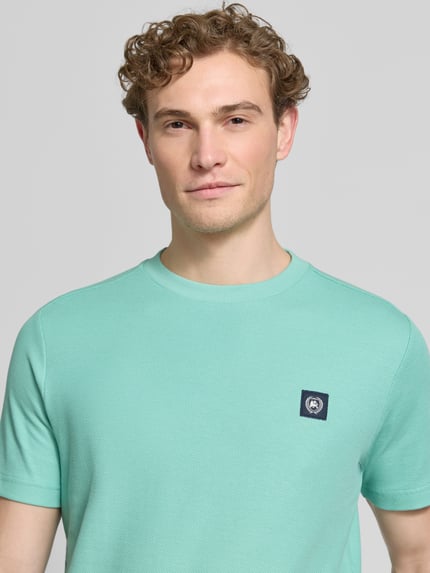 Männermodel trägt T-Shirt mit Label-Patch und Rundhalsausschnitt von Lerros in Mint, Reine Baumwolle, Gerader-Schnitt, Nahaufnahme Oberkörper. Herren T-Shirt, Rückenlänge Größe M 69 cm.