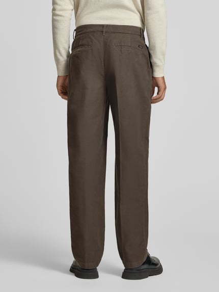 Männermodel trägt Bundfaltenhose mit Gesäßtaschen von Armani Exchange in Braun, Regular Fit, Label-Detail, Ganzkörperansicht Rückansicht.