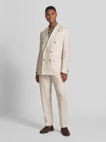 Männermodel trägt Regular Fit Sakko aus Leinen mit Pattentaschen von Christian Berg Men in Beige, Zweireiher, Ganzkörperansicht von vorne. Rückenlänge 74 cm, Schulterbreite 44 cm, Ärmellänge 65 cm, Reines Leinen, Reverskragen.