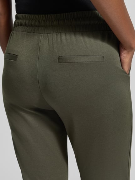 Frauenmodel trägt Hose mit elastischem Bund und Tunnelzug Modell 'KATE' von ICHI, Material-Mix, Slim Fit, Nahaufnahme Rückansicht.