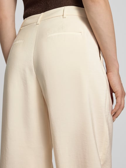Kobiece modelka ma na sobie Relaxed Fit Hose mit eingefassten Beinabschlüssen von Christian Berg Woman Selection, mieszanka modalu, zakładki w pasie, kieszenie z tyłu, zapięcie na guzik i zamek błyskawiczny, szerokość w rozmiarze 36: 40 cm, długość wewnętrzna nogawki w rozmiarze 36: 70 cm, jasny beżowy kolor, lekko połyskująca tekstura, delikatny materiał, detal tylnej części spodni, zbliżenie na pośladki, detalaufnahme.