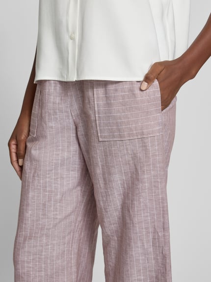 Vrouwenmodel draagt Wide Leg Pants aus Leinen-Mix mit Eingrifftaschen van MM by Max Mara, loose fit, elastische tailleband met koord, zijzakken, kleur lichtbruin met witte strepen; detailopname heupzijde