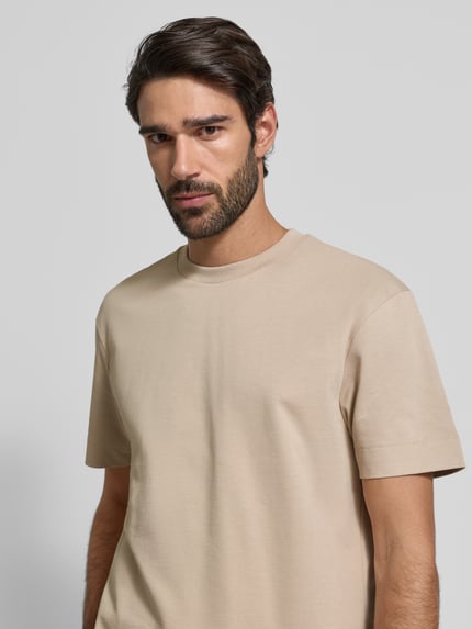 Männermodel trägt T-Shirt mit Label-Detail Modell 'Achilleas' von JOOP! Collection aus reiner Baumwolle in Regular-Fit, Nahaufnahme Oberkörper.