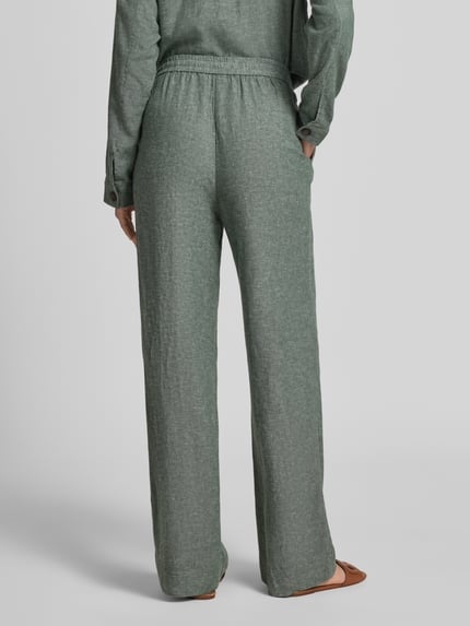 Vrouwenmodel draagt Leinenhose mit Kordelzug Modell 'Viana Ginia' van MSCH Copenhagen, groengrijze kleur, linnenmix, wide leg fit, Franse steekzakken, elastische taille met koord, binnenbeenlengte 80 cm, taillewijdte 37 cm, volledige achteraanzicht.