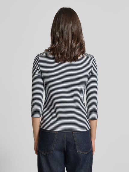Frauenmodel trägt Slim Fit T-Shirt aus reiner Baumwolle von Tommy Hilfiger, Optik: Two-Tone, gestreift, Logo-Detail, 3/4-Arm, Feinripp, Ganzkörperansicht Rückansicht.