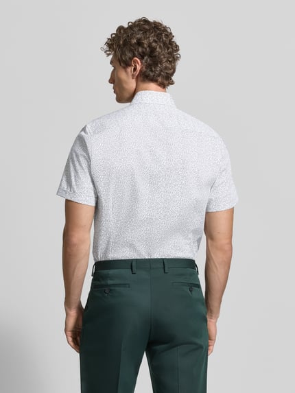 Männermodel trägt Slim Fit Business-Hemd mit Kentkragen von OLYMP Level Five, Baumwoll-Mix mit Stretch-Anteil, Ganzkörperansicht Rückansicht.