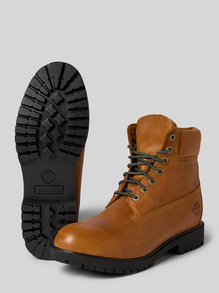 Produktfoto, Schnürboots aus echtem Leder von Timberland, brauner Schuh mit profilierter schwarzer Sohle, Schnürverschluss, Label-Prägung, abgerundete Form, Absatzhöhe 3 cm, Schafthöhe 15 cm, Schaftweite 11 cm.