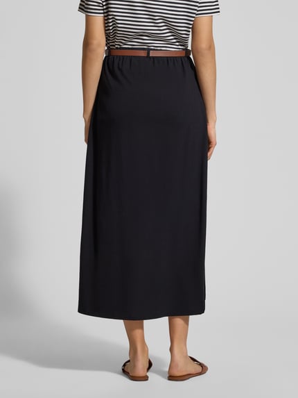 Vrouwenmodel draagt Maxi-Rock aus Baumwoll-Mix Modell 'LUNA' van Vero Moda in effen zwart, elastische tailleband, maxi lengte, rechte zoom, materiaal jersey katoenmix, licht uitlopend fit, met riem en riemlussen. Volledige lichaamsweergave achterkant.