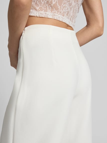 Frauenmodel trägt Straight Fit Stoffhose mit Viskose-Anteil Modell 'Leonie' von GUIDO MARIA KRETSCHMER WOMAN, Elastischer-Material-Mix, weites Bein, Ziernähte, cremeweiße Textur, Detailaufnahme Hüfte.