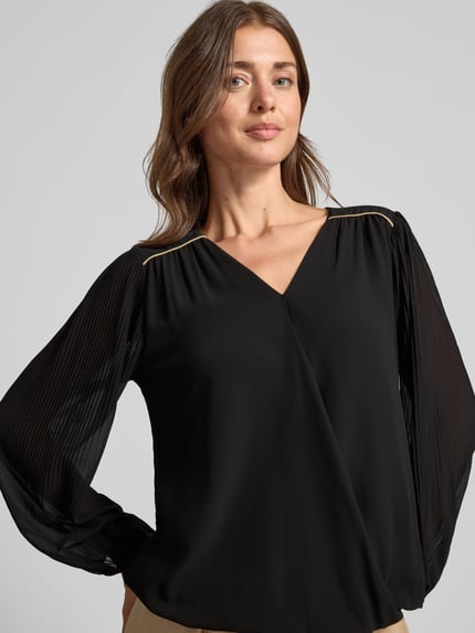 Frauenmodel trägt Bluse mit V-Ausschnitt Modell 'Be44rtaa' von ZABAIONE in Schwarz, elastische Abschlüsse, Nahaufnahme Oberkörper.