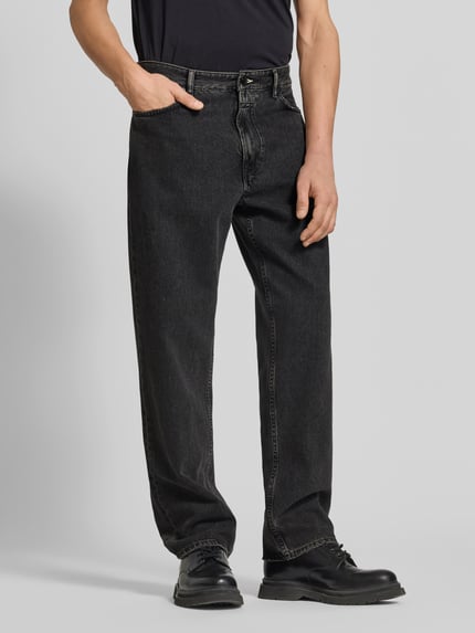 Männermodel trägt Relaxed Fit Jeans aus reiner Baumwolle von Closed in Schwarz, 5-Pocket-Design, Knopf- und Reißverschluss, Ganzkörperansicht von vorne
