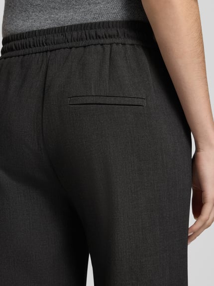 Frauenmodel trägt Regular Fit Hose mit elastischem Bund Modell 'Christy Clean' von MAC, strukturierte unifarbene Wide Leg Hose, Ziertasche, Gummizug, Tunnelzug, Detailaufnahme Rückansicht.