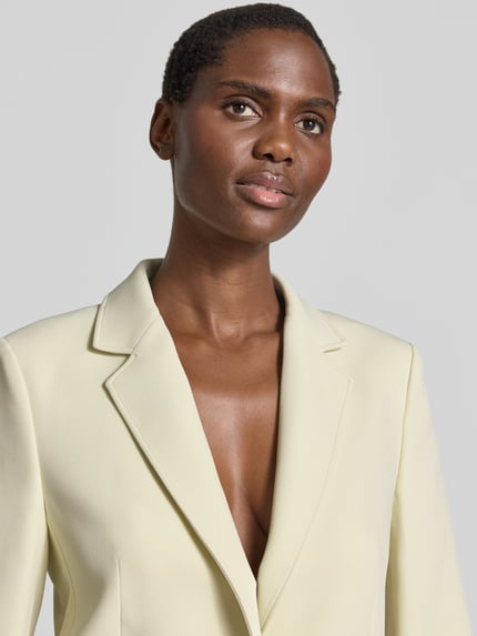 Frauenmodel trägt Regular Fit Longblazer mit Reverskragen Modell 'JABLA3' von BOSS Orange, Optik: Unifarben, Nahaufnahme Oberkörper.