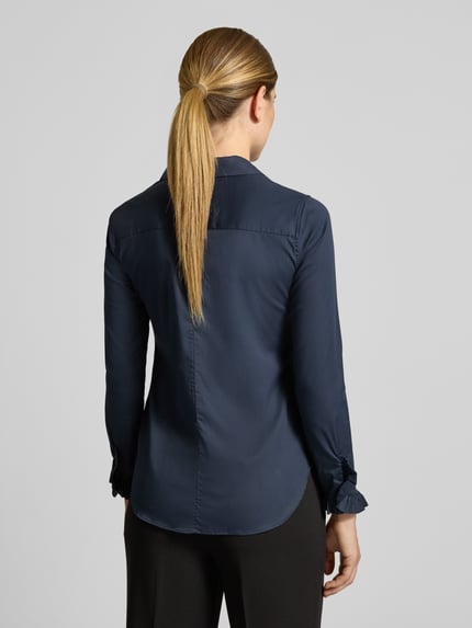 Frauenmodel trägt Hemdbluse aus Baumwoll-Mix Modell 'Mattie' von MOS MOSH in Dunkelblau mit Rüschen, Ganzkörperansicht Rückansicht. Slim Fit, elastisch, durchgehende Knopfleiste, langärmelig, Hemdblusenkragen, abgerundeter Saum, Rückenlänge 70 cm, Ärmellänge 62 cm.