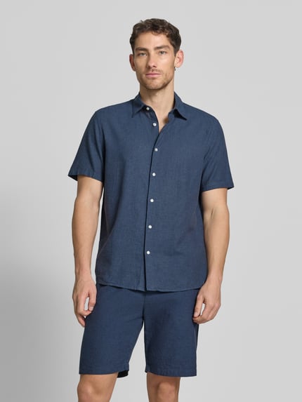 Männermodel trägt Regular Fit Freizeithemd aus Leinen-Baumwoll-Mix von MCNEAL in Dunkelblau, Kentkragen, Knopfleiste, Ganzkörperansicht von vorne. Rückenlänge bei Größe M: 74 cm, Schulterbreite 50 cm, Ärmellänge 25 cm.