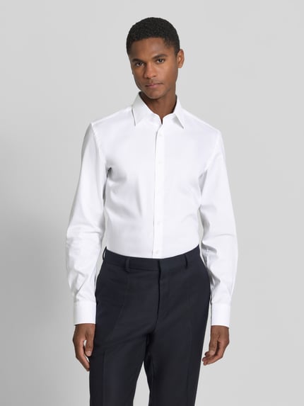 Mężczyzna model nosi Slim Fit Businesshemd aus reiner Baumwolle Modell 'HANK' od BOSS, biała gładka popelina, przód, ujęcie całej sylwetki.