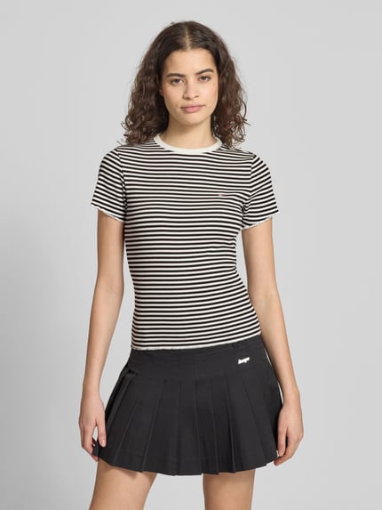 Frauenmodel trägt Slim Fit T-Shirt aus Baumwoll-Mix von Tommy Hilfiger, schwarz-weiß gestreift, Rundhals, Frill-Abschluss, Nahaufnahme Oberkörper.