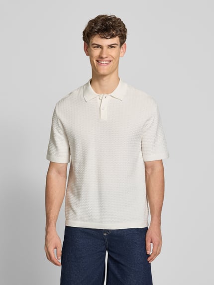 Männermodel trägt Relaxed Fit Poloshirt Modell 'FERDINAND' von Redefined Rebel aus Reine Baumwolle, Strickshirt, Knopfleiste, Rückenlänge bei Größe M 70 cm, Ganzkörperansicht von vorne.
