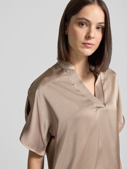 Frauenmodel trägt Blusenshirt aus Satin mit V-Ausschnitt Modell 'Anelle' von Neo Noir in Beige, Regular Fit, Nahaufnahme Oberkörper.