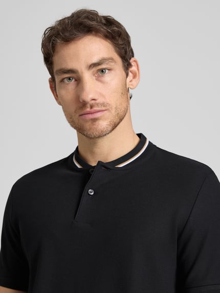 Männermodel trägt Regular Fit Poloshirt aus einer Baumwolle C-PRATT40 von BOSS, Optik: Unifarben, Piqué, Nahaufnahme Oberkörper.