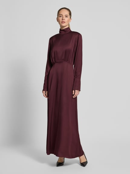 Frauenmodel trägt Fließendes Kleid in Maxilänge - curated by Isabelle Hartmann von Style Icon Collection in dunklem Satin, taillierte Passform, Stehkragen, Langärmelig, Maxilänge, Unifarbenes-Design, Ganzkörperansicht von vorne. Rückenlänge bei Größe 36: 146 cm, Brustweite: 35 cm, Ärmellänge: 66 cm.