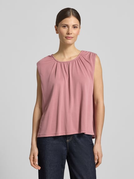 Vrouwenmodel draagt Loose Fit Blusentop uit modalmix model 'FILLI' van Vero Moda, look: effen, pasvorm: loose fit, ronde hals, mouwloos, materiaalverwerking: stretch, materiaal: modalmix, bovenstuk in zachtroze, gladde textuur, geheel lichaamsaanzicht van voren.