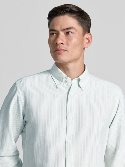 Männermodel trägt Regular Fit Freizeithemd aus Lyocell-Baumwoll-Mix Modell 'RICOPLUS' von BOSS Orange, gestreift, Nahaufnahme Oberkörper.