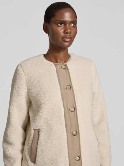 Frauenmodel trägt Regular Fit Webpelzjacke mit Knopfleiste Modell 'FRANCESCA' von VERO MODA, cremefarben, strukturierte Oberfläche, Nahaufnahme Oberkörper, Damen Teddy- / Webpelzjacke.