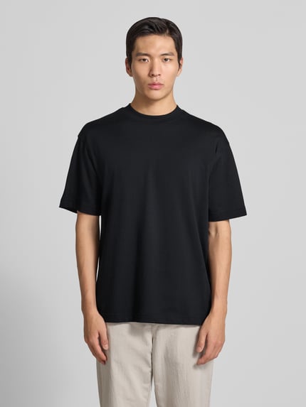 Männermodel trägt Regular Fit T-Shirt aus Baumwoll-Mix Modell 'TEETIM' von BOSS Orange, Optik: Unifarben, Label-Print, Rundhals, Ganzkörperansicht von vorne.