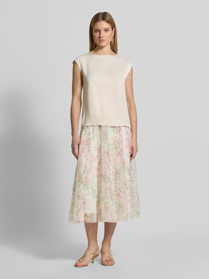 Frauenmodel trägt Midirock mit elastischem Logo-Bund von JOOP! aus Chiffon in zartem Pastell mit A-Linie, Modell FRIDI, Ganzkörperansicht von vorne.