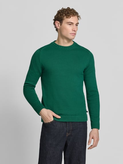 Männermodel trägt Pullover mit markanten Teilungsnähten von S.OLIVER CASUAL in Grün, Feinstrick-Struktur, unifarben, Ganzkörperansicht von vorne
