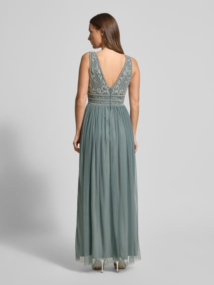 Vrouwenmodel draagt avondkleid met parel- en siersteenversiering van Lace & Beads, mix van materialen, lange uitlopende rok, v-hals, detailrijke rug, zichtbare naadrits, maxilengte, gedetailleerde zoom, rugaanzicht.