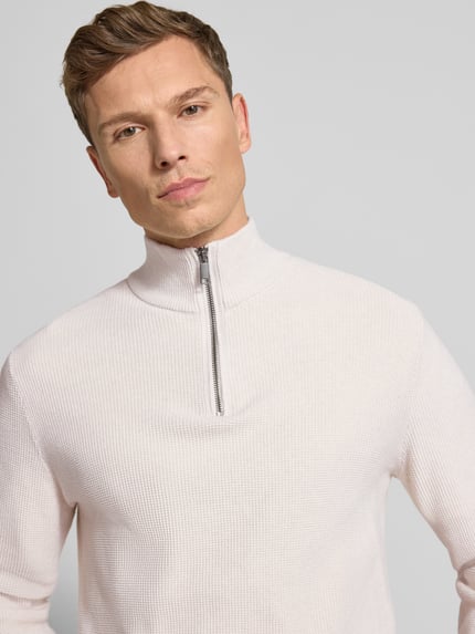 Męski model nosi Strickpullover mit Stehkragen od MCNEAL, bawełna, slim fit, jasny kolor, krótkie zamknięcie, zbliżenie na górę ciała.