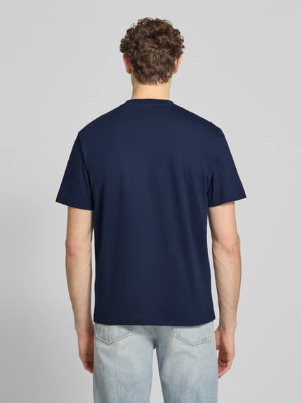 Männermodel trägt Regular Fit T-Shirt aus reiner Baumwolle von Lacoste, Optik: Unifarben, Passform: Regular-Fit, Logo-Stitching, Label-Print, Rundhals, Material: Reine Baumwolle, dunkelblau, glatte Textur, Ganzkörperansicht Rückansicht.