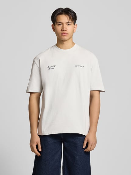 Männermodel trägt Oversized T-Shirt mit 1/2-Arm Modell 'Zernez' von Pegador in Reine Baumwolle, mit Rundhalsausschnitt, Label-Detail, Ganzkörperansicht von vorne.