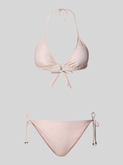 Produktfoto, Bikini mit wattierten Cups und seitlicher Schnürung von Banana Moon in zartem Rosa mit leicht glänzender Textur, Modell CRICOMASSA GLITTERWAVE, Triangel-Form, Schleifendetails, Herz-Anhänger und Label-Detail, gefertigt aus Material-Mix mit Stretch-Anteil.