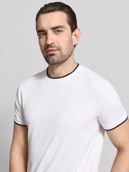 Männermodel trägt T-Shirt mit Rundhalsausschnitt und Kontraststreifen von Manuel Ritz, Slim Fit, weiß, glatte Struktur, Nahaufnahme Oberkörper.