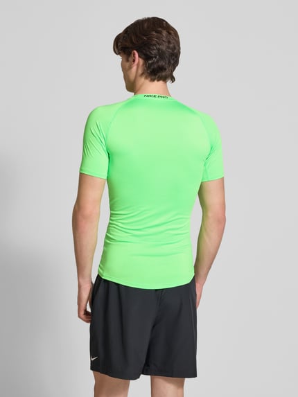 Mężczyznamodel nosi T-Shirt mit Logo-Print und Rundhalsausschnitt von NIKE TRAINING, krój slim fit, okrągły dekolt, nadruk z logo, raglanowe rękawy, długość tyłu w rozmiarze m: 72 cm, widok całej sylwetki z tyłu.