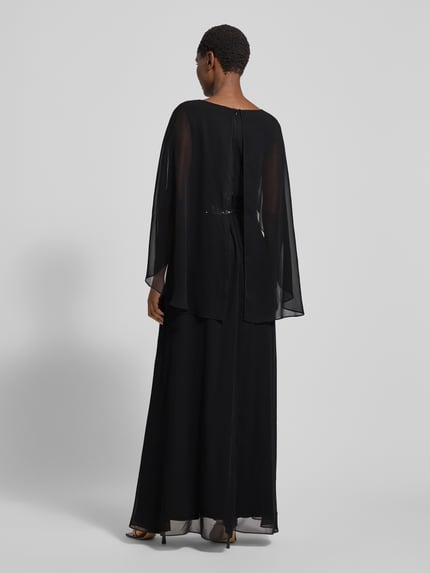 Frauenmodel trägt Abendkleid mit V-Ausschnitt und Pailletten von Swing in Schwarz, fließender Stoff, taillierter Schnitt, Maxikleid, Ganzkörperansicht Rückansicht.