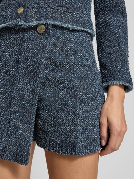 Vrouwenmodel draagt Skort in Wickeloptik mit seitlichem Reißverschluss van Marc Cain, blauwe A-lijn structuur, pure katoen, detailopname heupen.