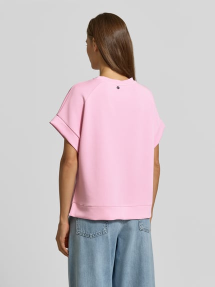 Modelka prezentuje T-Shirt mit elastischen Abschlüssen von Rich & Royal, różowy, mieszanka modalu z dodatkiem streczu, krój relaxed fit, okrągły dekolt, damski t-shirt, wykończenia: elastyczne, widok całej sylwetki z tyłu.