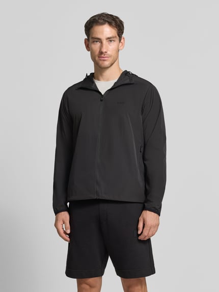 Männermodel trägt schwarze Regular Fit Trainingsjacke mit Label-Print Modell 'OW_Airynix JT HD 2' von BOSS Green, Ganzkörperansicht von vorne.