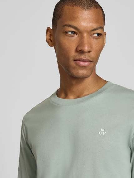 Männermodel trägt Shaped Fit Langarmshirt aus reiner Baumwolle von Marc O'Polo in hellem Grün, glatte Textur, Nahaufnahme Oberkörper, Herren Langarmshirt von Marc O'Polo